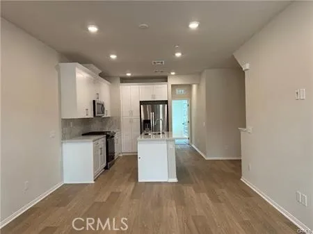 a view of a kitchen with a sink and a refrigerator