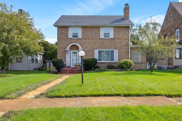 a front view of a house with a garden and plants