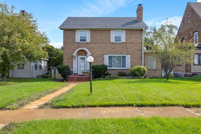 a front view of a house with a garden and plants