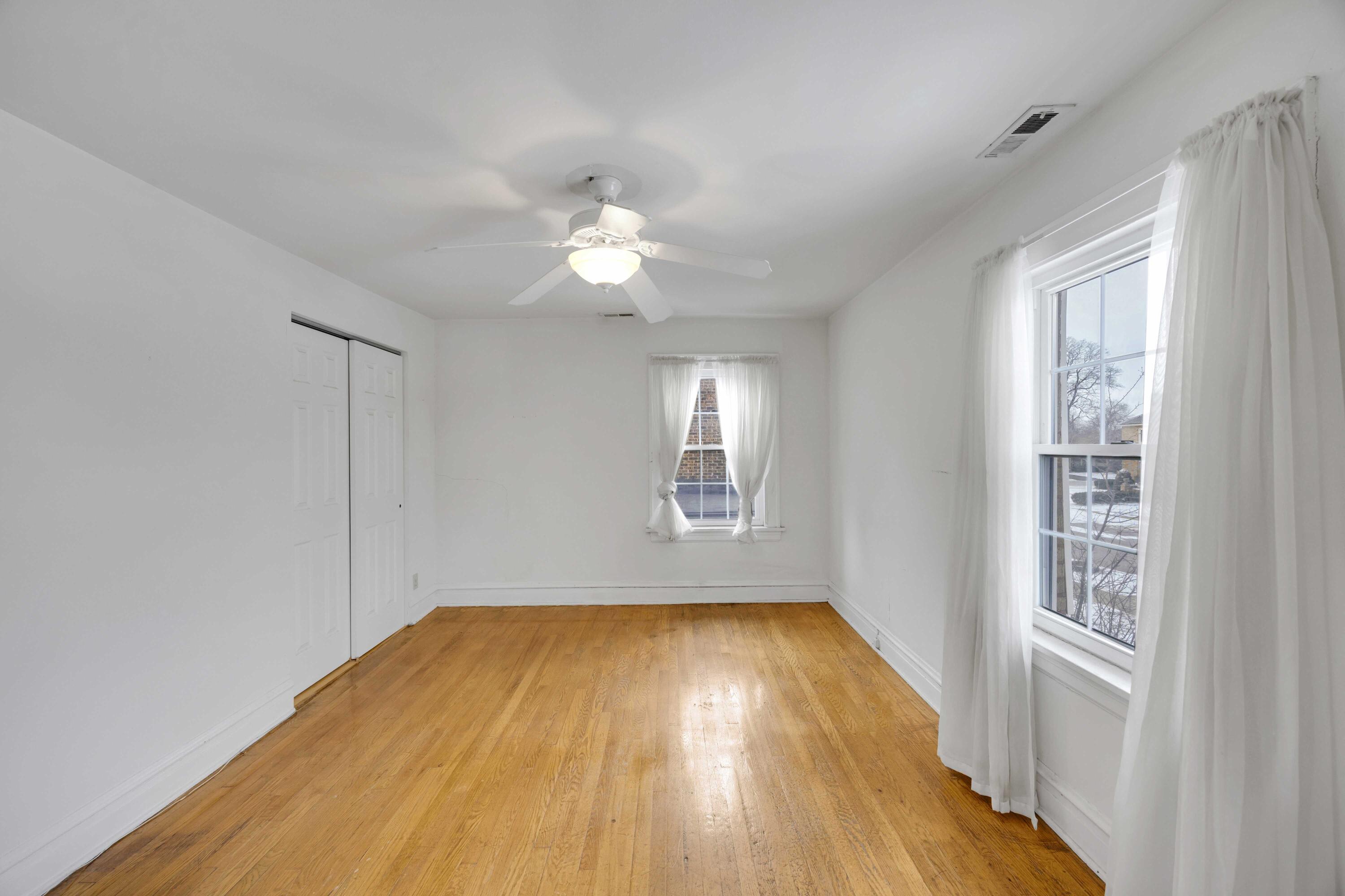 643 McKinley Street Gary, IN 46404 - Photo 13 of 22 an empty room with wooden floor and windows