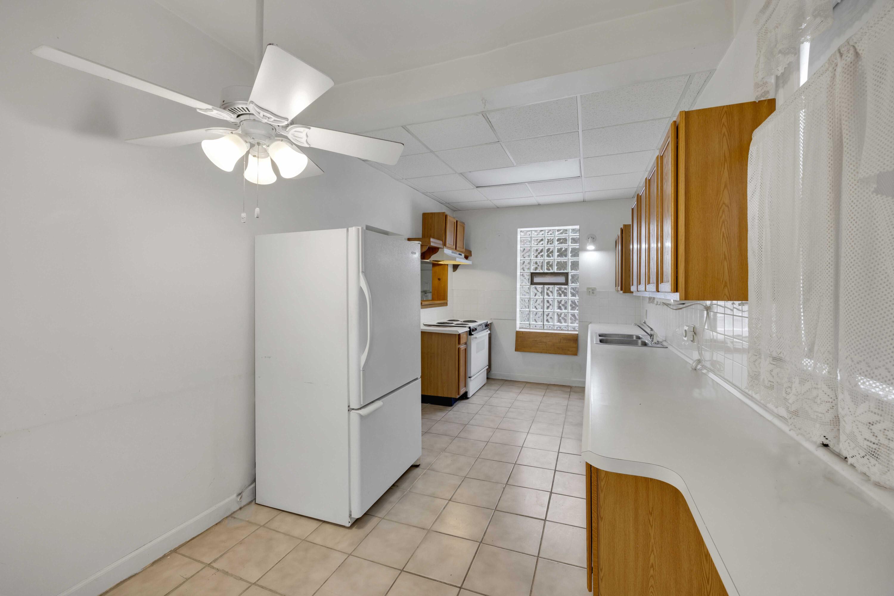 643 McKinley Street Gary, IN 46404 - Photo 6 of 22 a view of a kitchen with a refrigerator and a stove top oven