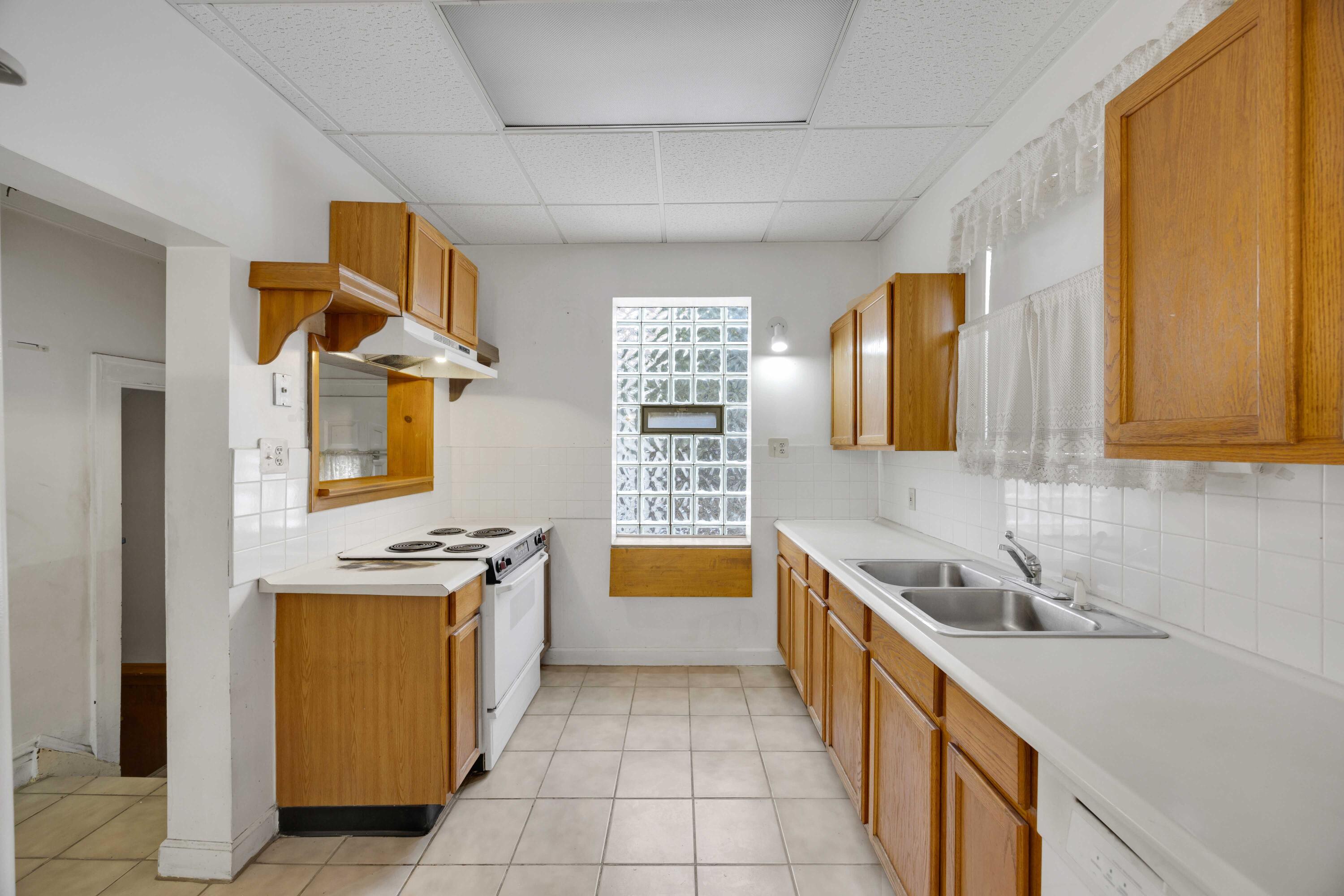 643 McKinley Street Gary, IN 46404 - Photo 7 of 22 a kitchen with a sink and wooden cabinets