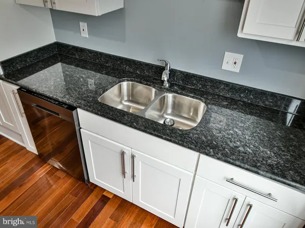 a kitchen with granite countertop a sink and a stove