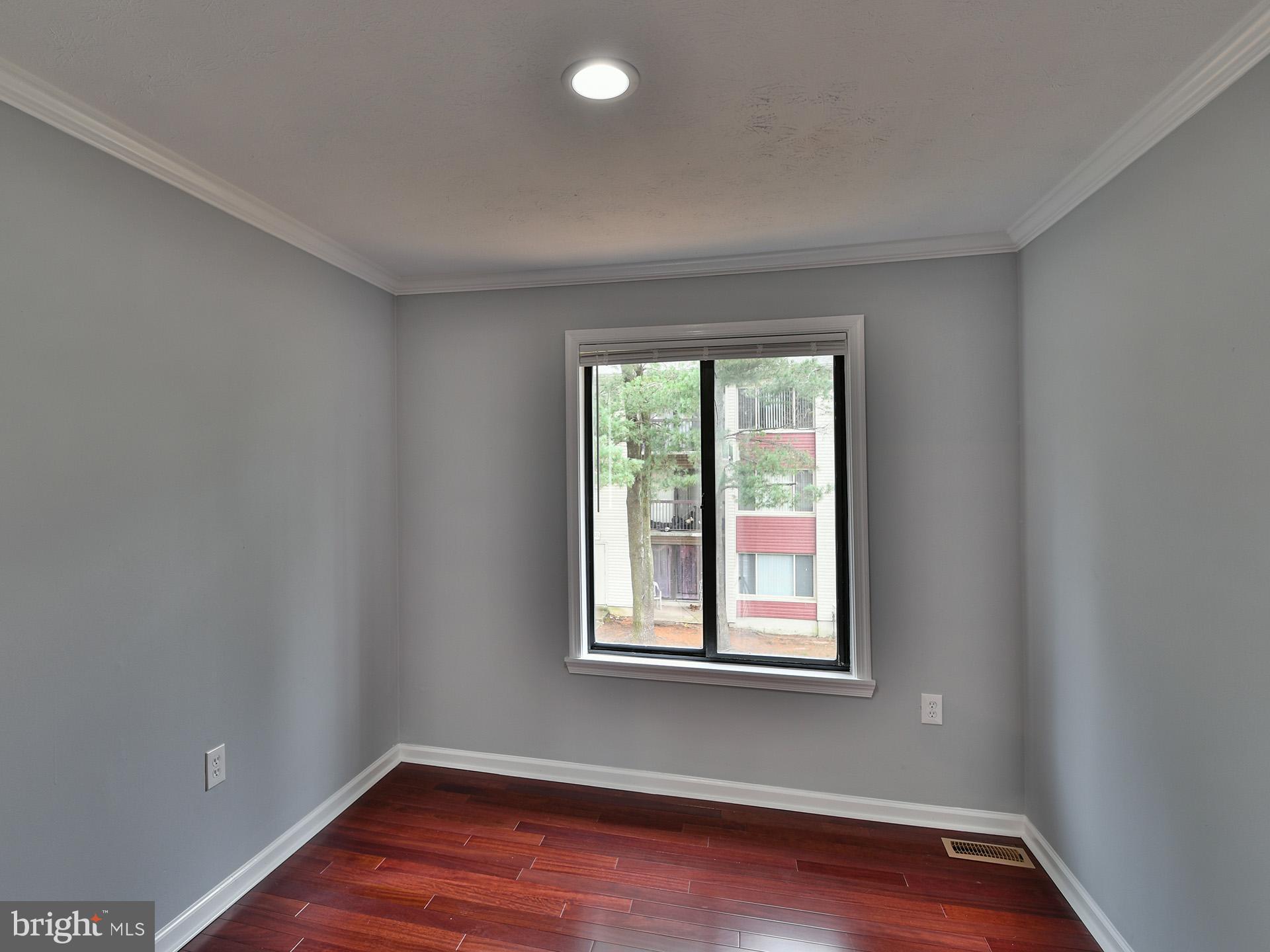 3511 Castle Way, Unit 312 Silver Spring, MD 20904 - Photo 24 of 34 a view of an empty room with wooden floor and a window