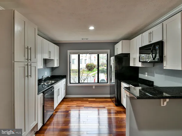 a kitchen with stainless steel appliances a stove sink microwave and cabinets
