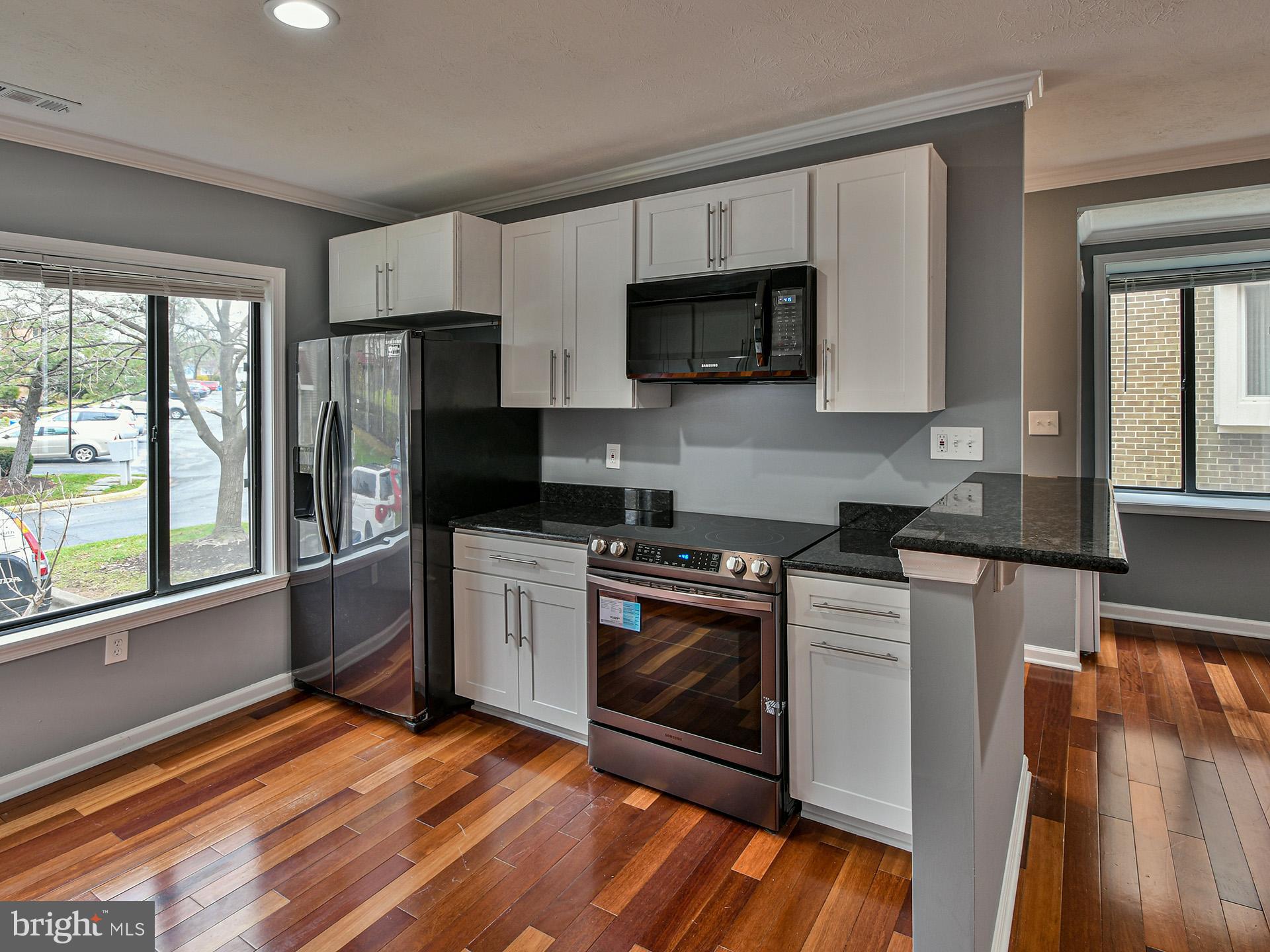 3511 Castle Way, Unit 312 Silver Spring, MD 20904 - Photo 9 of 34 a kitchen with stainless steel appliances granite countertop a stove a sink and a refrigerator