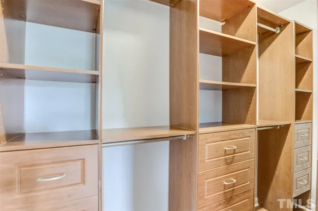 a view of walk in closet with empty racks