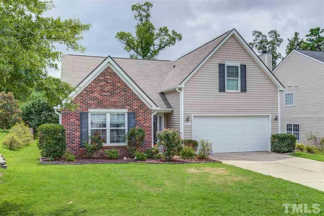 a view of a house with a yard and potted plants