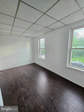 a view of a room that has wooden floor and brick walls