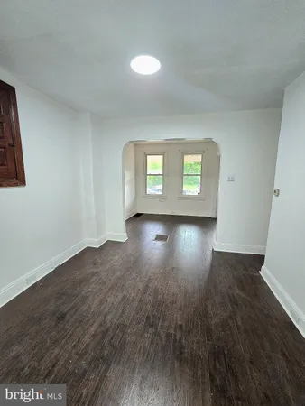 a empty room with wooden floor and windows