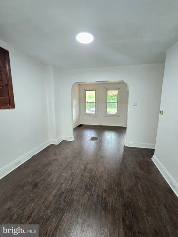a empty room with wooden floor and windows