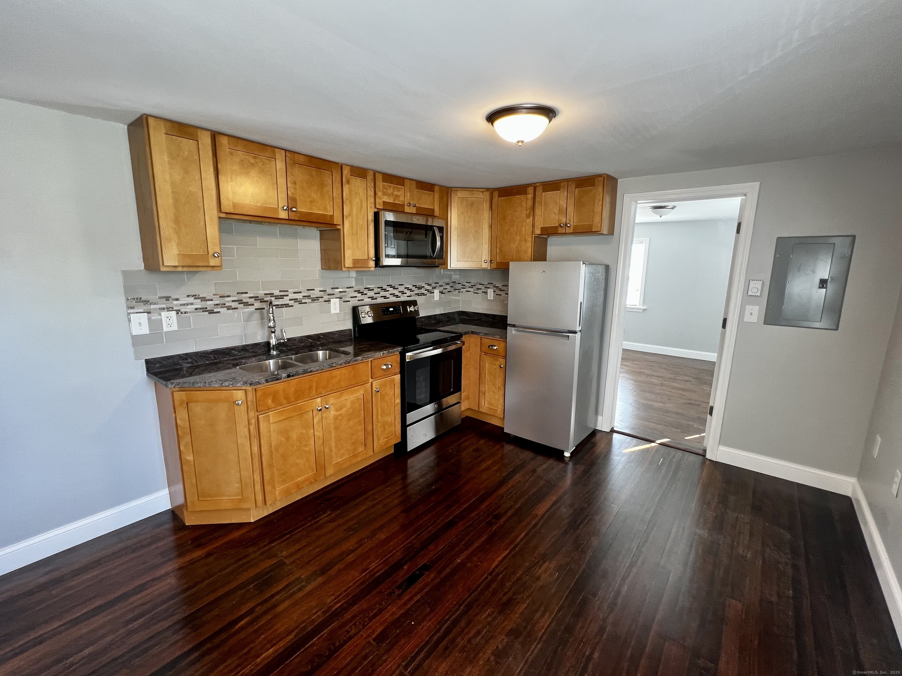 a kitchen with stainless steel appliances granite countertop wooden floors and a stove