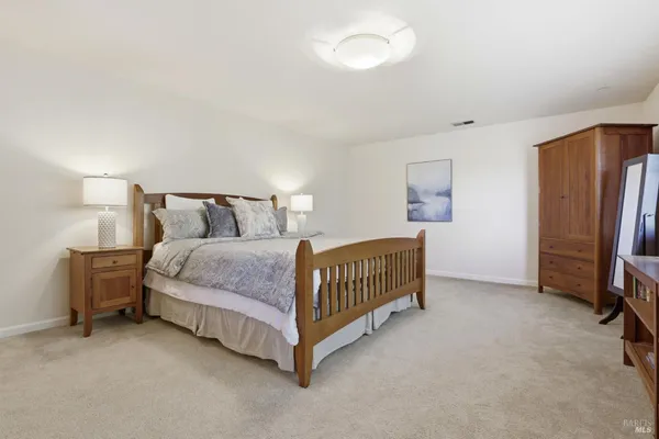 a bedroom with a bed and a refrigerator