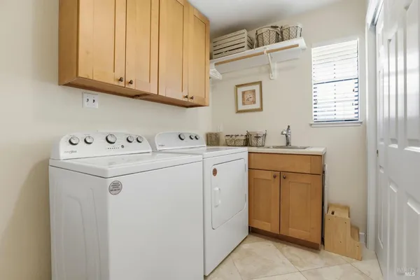 a utility room with sink dryer and washer