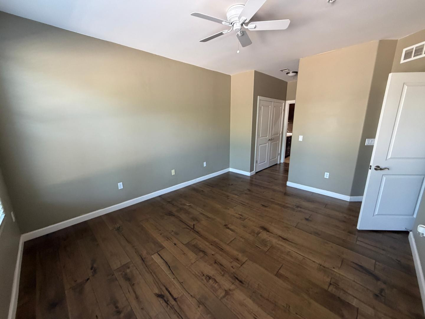 7291 North Scottsdale Road, Unit 1001 Paradise Valley, AZ 85253 - Photo 13 of 34 an empty room with wooden floor and a ceiling fan