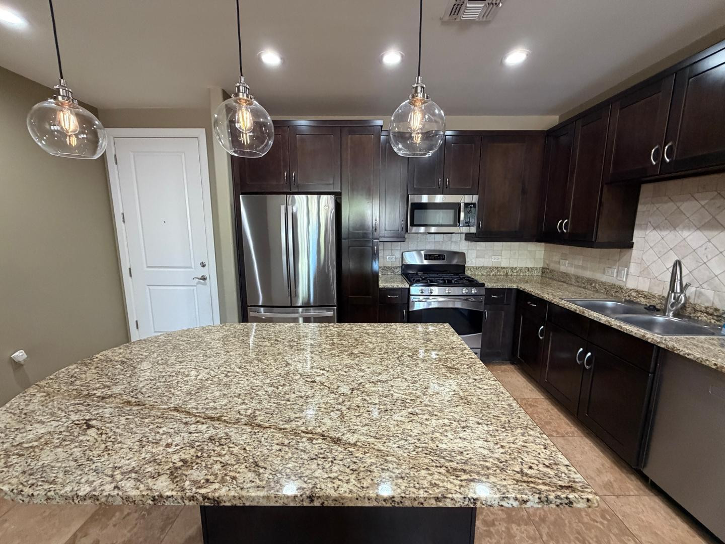7291 North Scottsdale Road, Unit 1001 Paradise Valley, AZ 85253 - Photo 4 of 34 a kitchen with kitchen island granite countertop wooden cabinets and refrigerator
