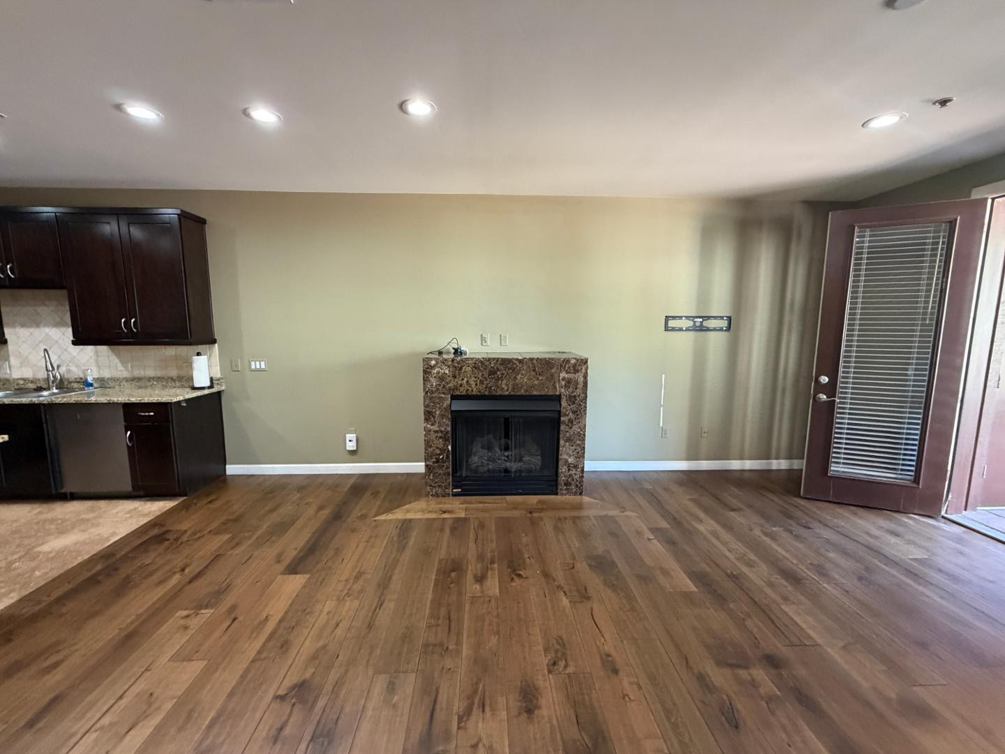 7291 North Scottsdale Road, Unit 1001 Paradise Valley, AZ 85253 - Photo 5 of 34 a view of an empty room with wooden floor and a fireplace