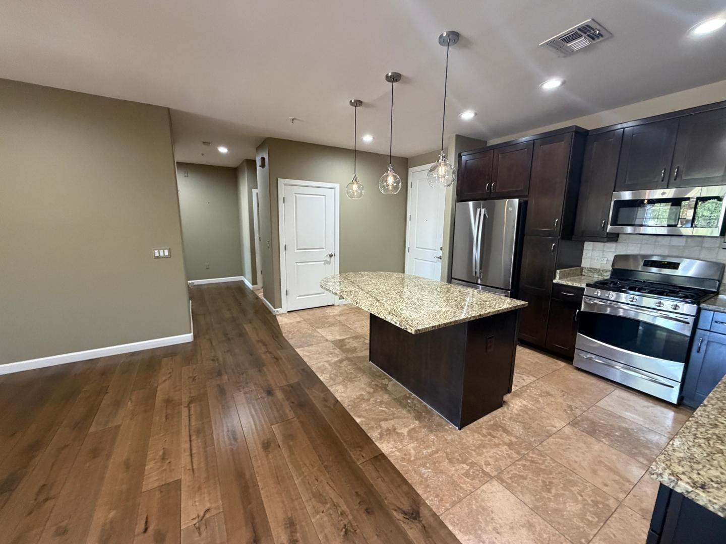 7291 North Scottsdale Road, Unit 1001 Paradise Valley, AZ 85253 - Photo 7 of 34 a large kitchen with stainless steel appliances kitchen island granite countertop a large counter top and wooden floors