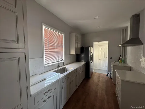 a kitchen with granite countertop a sink and a refrigerator
