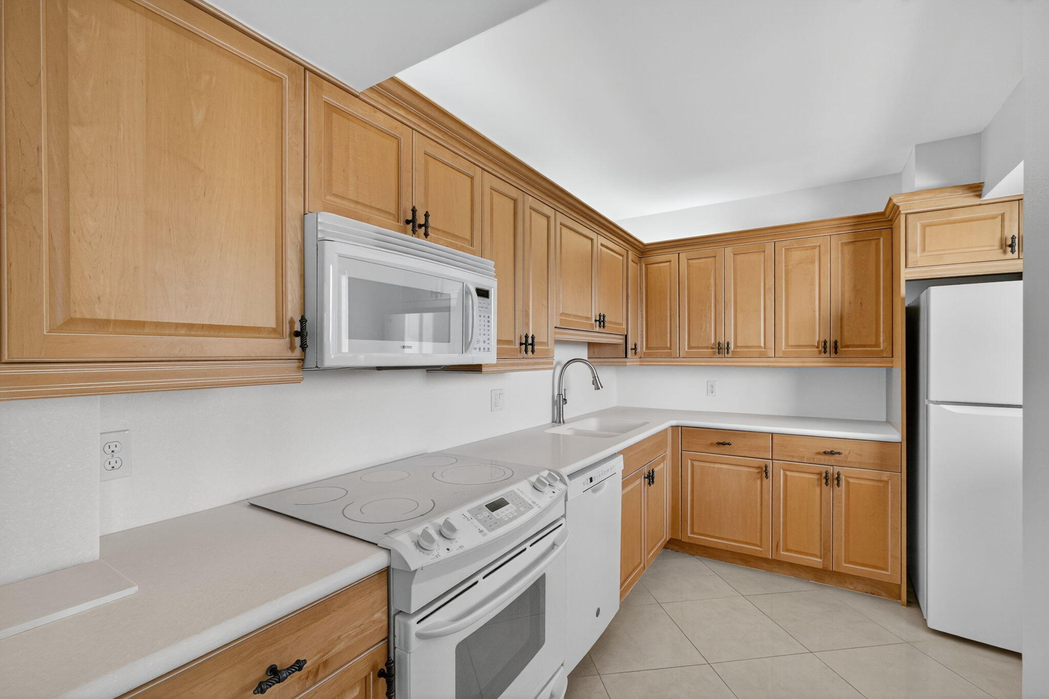 100 Ocean Trail Way, Unit 305 Jupiter, FL 33477 - Photo 7 of 53 a kitchen with a sink cabinets and stainless steel appliances