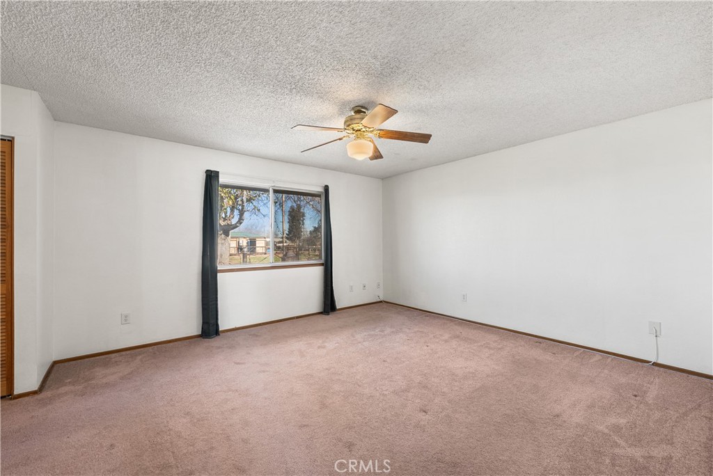 10837 East Ave R 10 Littlerock, CA 93543 - Photo 22 of 50 an empty room with chandelier fan and windows