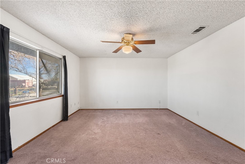 10837 East Ave R 10 Littlerock, CA 93543 - Photo 25 of 50 an empty room with windows and a chandelier fan