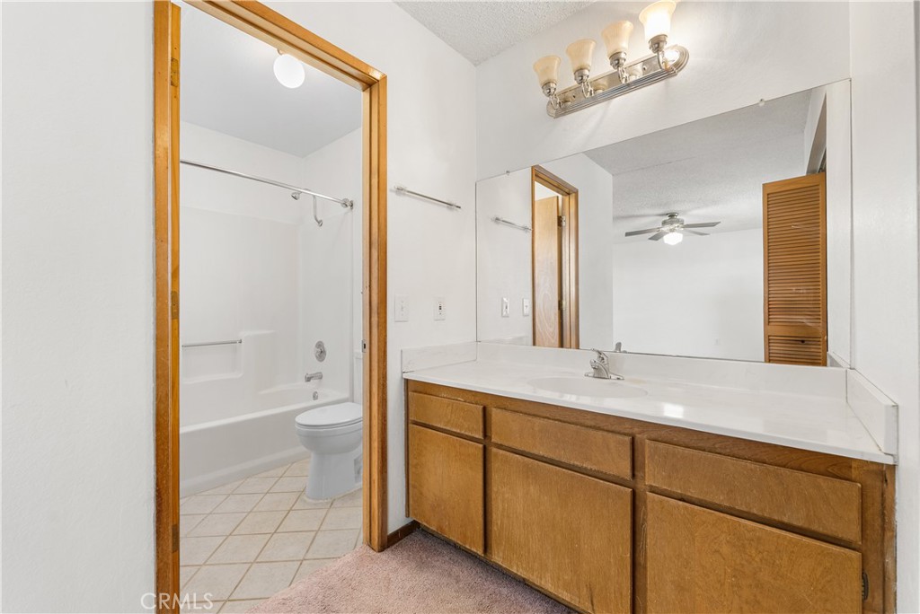 10837 East Ave R 10 Littlerock, CA 93543 - Photo 26 of 50 a bathroom with a granite countertop sink mirror and a toilet