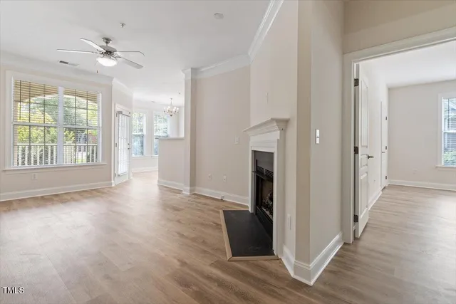a view of a room with wooden floor and a ceiling fan