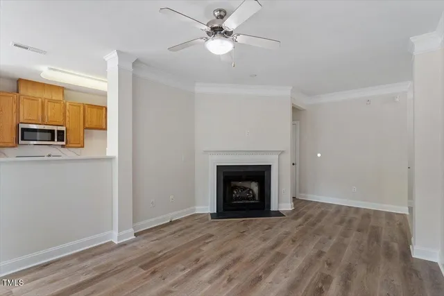 an empty room with a fireplace and a ceiling fan