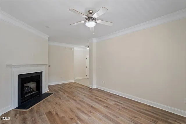 an empty room with fan and fireplace