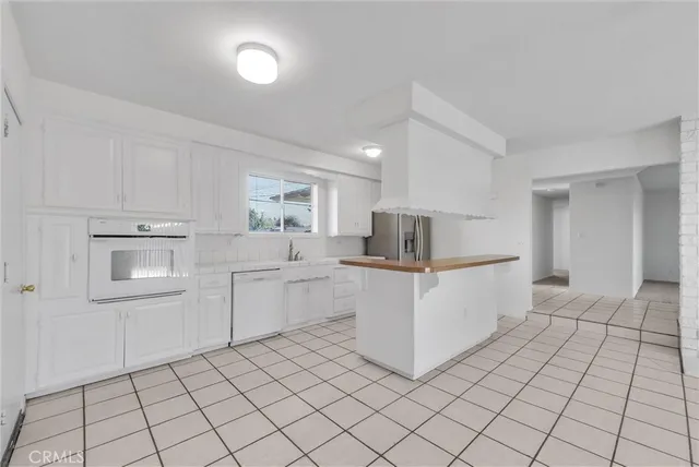 a kitchen with white cabinets a sink and white appliances