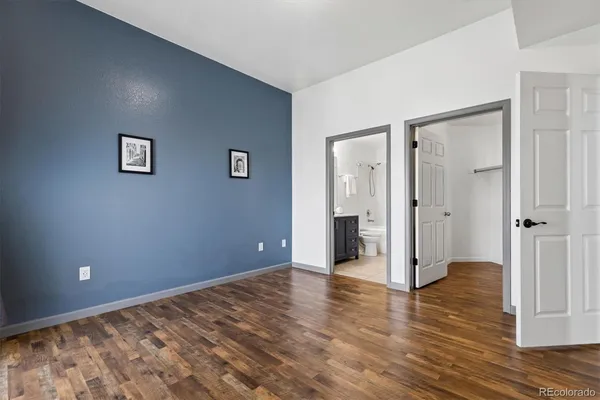 an empty room with wooden floor and a bathroom
