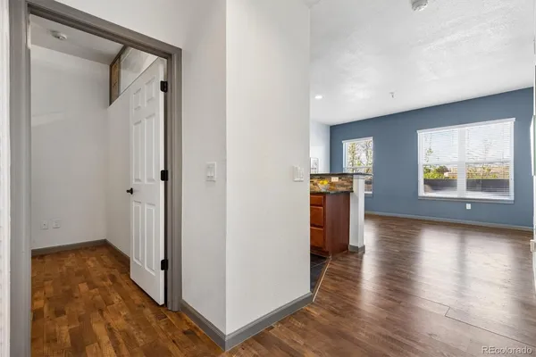 a view of a hallway with wooden floor and windows