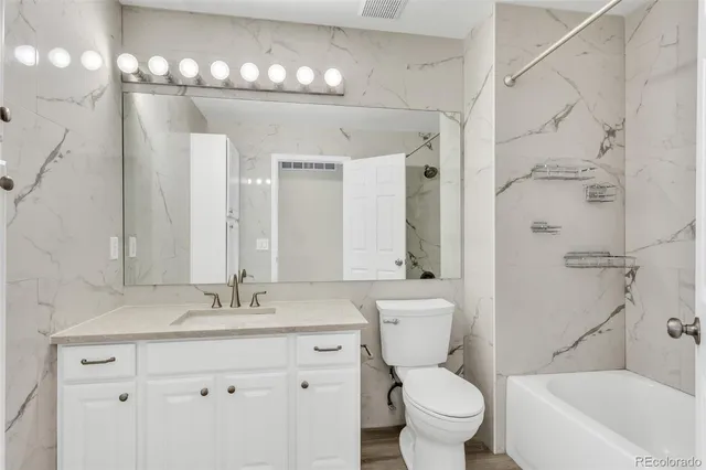 a bathroom with a sink a toilet and a large mirror
