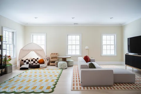 a bedroom with a bed and a chair with the bookshelf