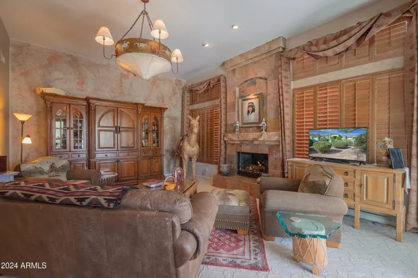 a living room with furniture a fireplace and a chandelier