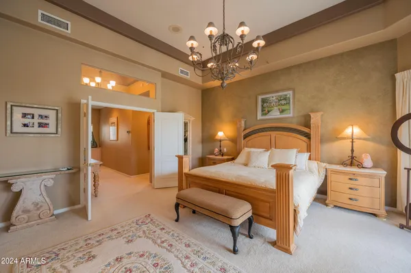 a bedroom with a bed and a chandelier