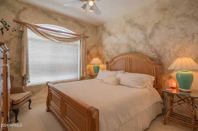 a bedroom with a bed and chair with the outer view