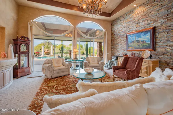 a living room with furniture chandelier and a large window