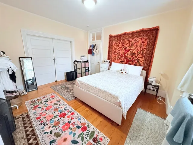 a bedroom with a bed and a fireplace with wooden floor