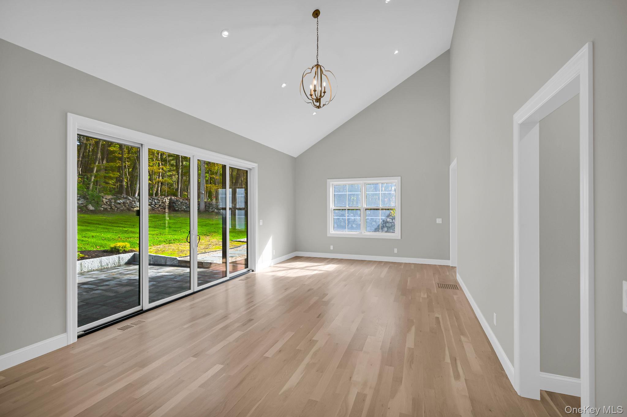 170 Brimstone Road Patterson, NY 12563 - Photo 12 of 48 featuring a chandelier, high vaulted ceiling, and light wood-type flooring, sliding doors with extra window panes