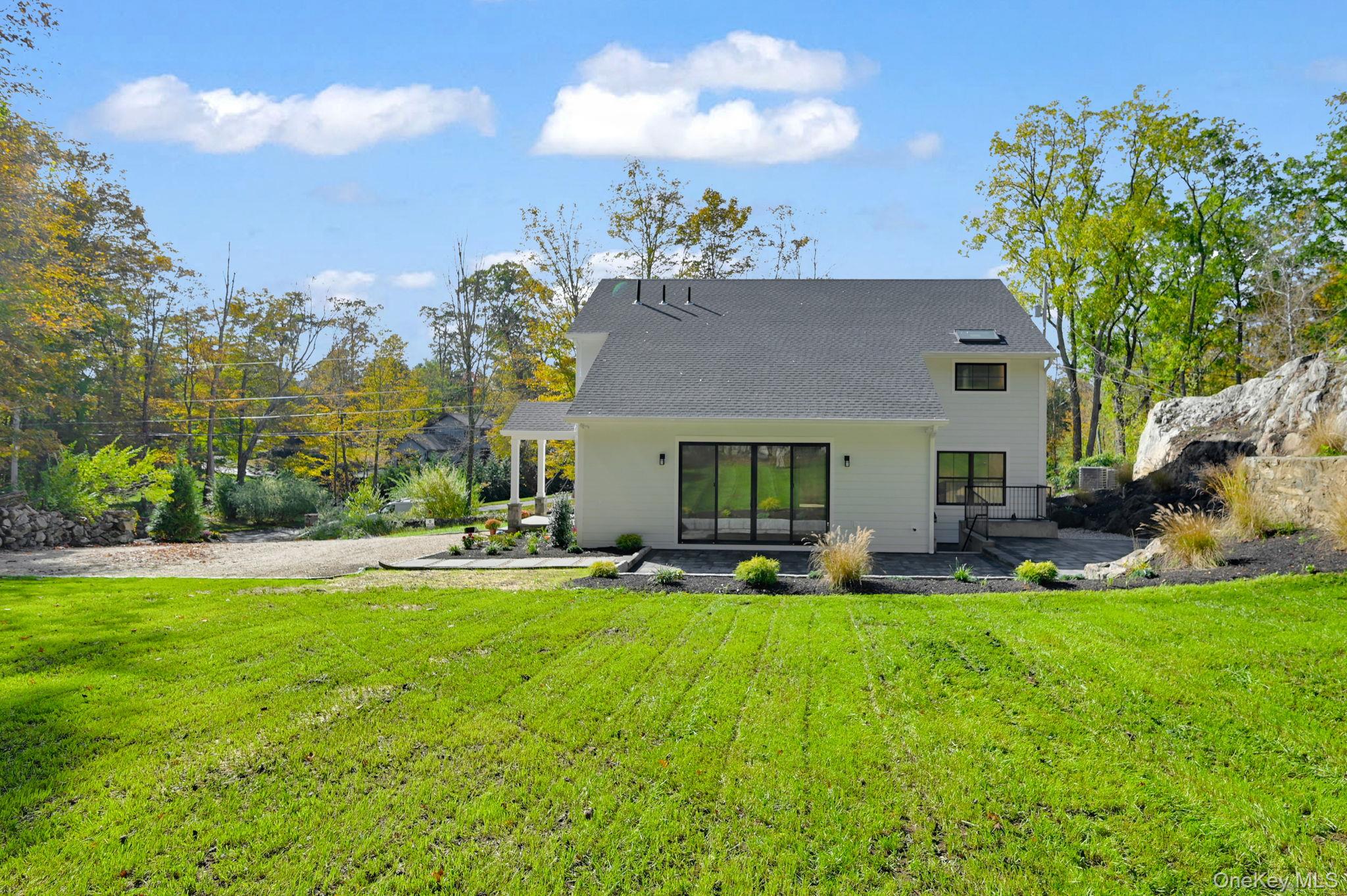 170 Brimstone Road Patterson, NY 12563 - Photo 40 of 48 Back of house featuring a lawn, a patio, and a shingled roof