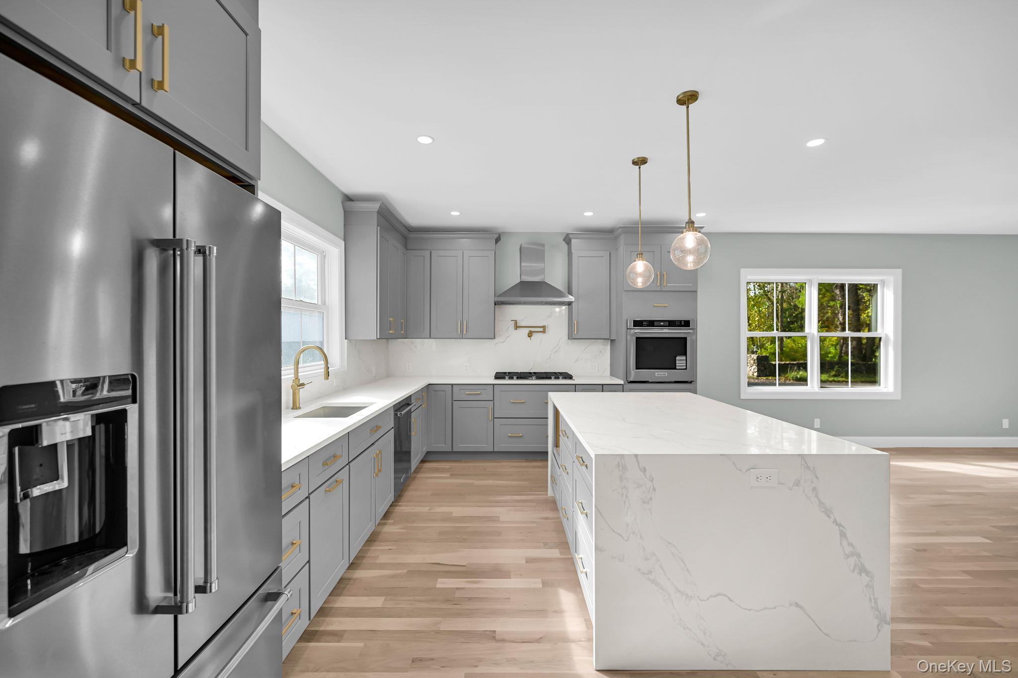170 Brimstone Road Patterson, NY 12563 - Photo 5 of 48 Kitchen with gray cabinets, stainless steel appliances, light stone counters, backsplash, and White oak wood floors
