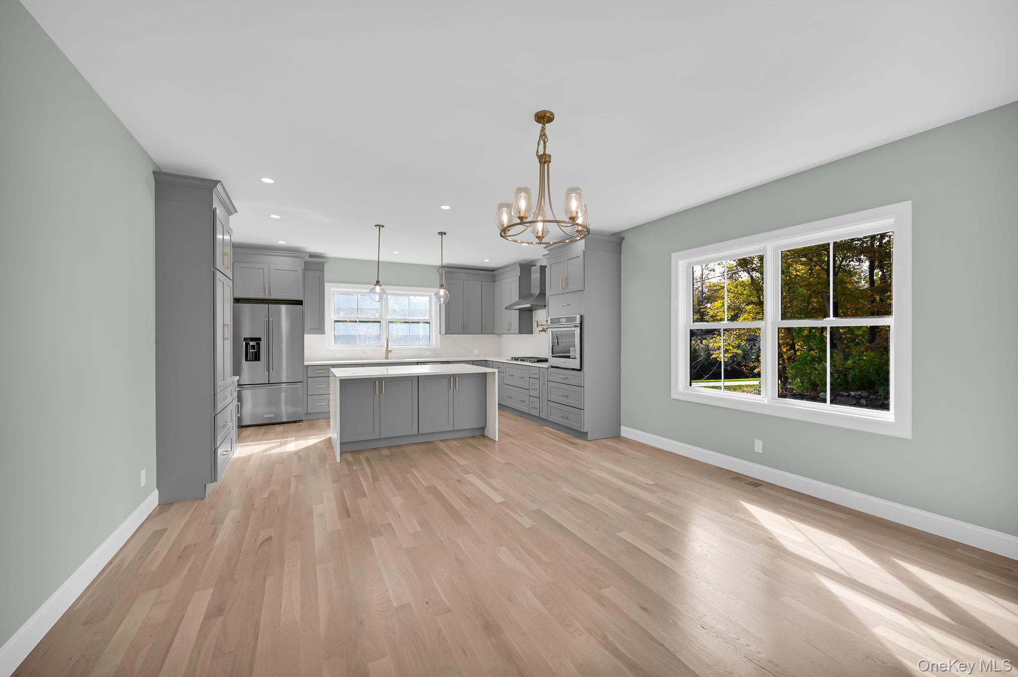 170 Brimstone Road Patterson, NY 12563 - Photo 8 of 48 Kitchen with gray cabinets, decorative light fixtures, light countertops, light wood-type flooring, and stainless steel appliances