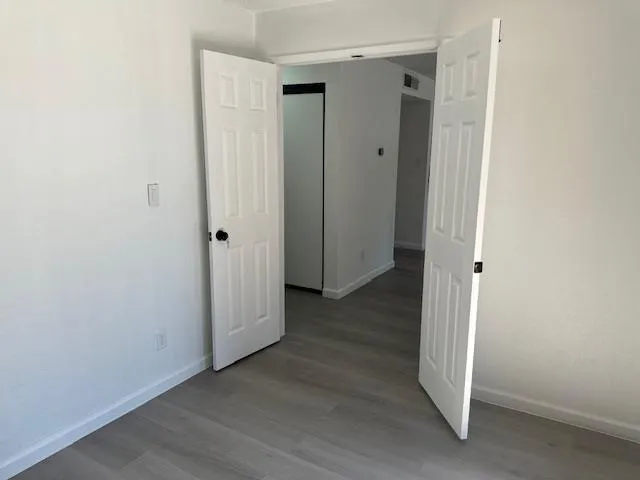 a view of a hallway with wooden floor