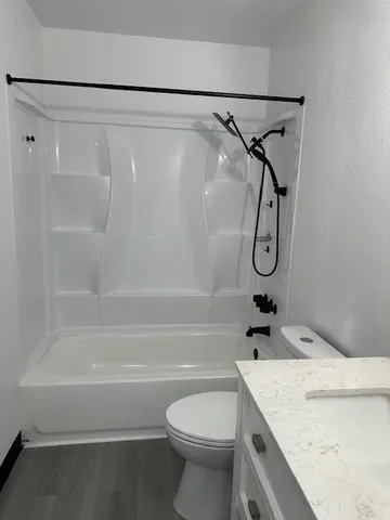 a bathroom with a granite countertop sink toilet and shower