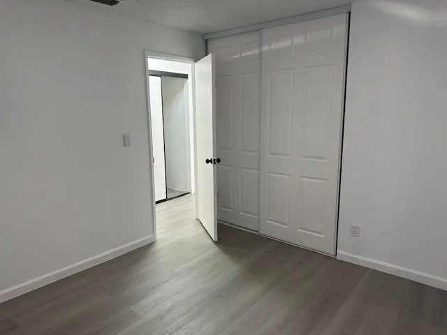 an empty room with wooden floor and closet