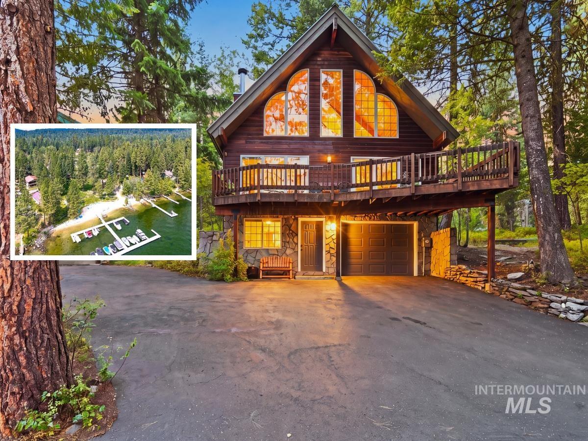 1571 Warren Wagon Road McCall, ID 83638 - Photo 1 of 50 Striking A-frame residence nestled among mature pine and fir trees, featuring a dark wood exterior with expansive upper-level deck and large transom windows flooding the interior with natural light