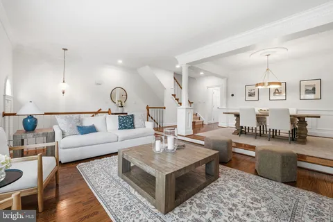 a dining room with wooden floor a chandelier a wooden table and chairs