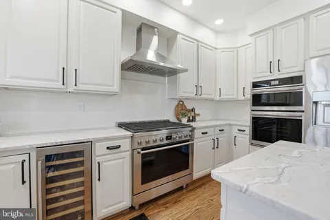 a bathroom with a sink a large mirror and a potted plant